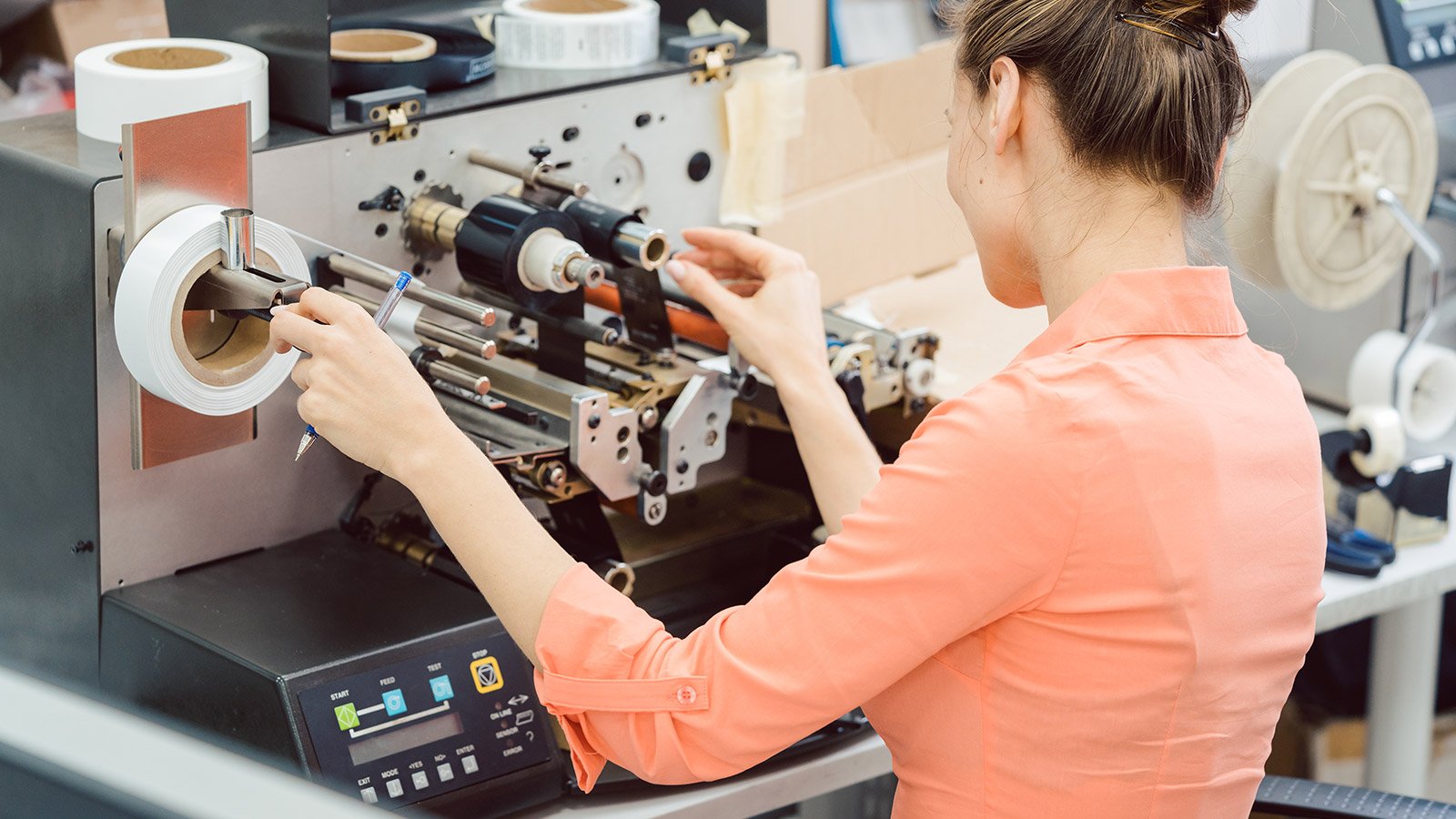 Woman working on label printing machine