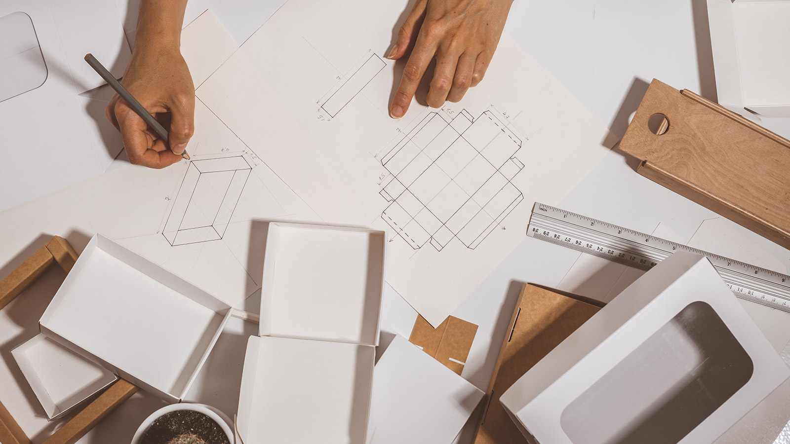 Designer drawing a mockup for economic cardboard box