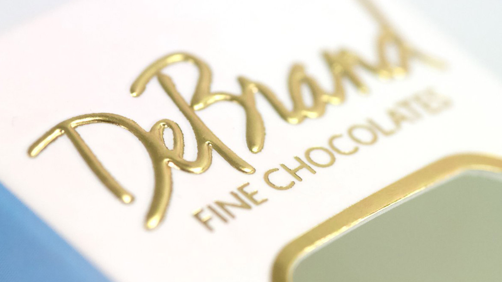 Close up of shiny gold DeBrand Fine Chocolate packaging