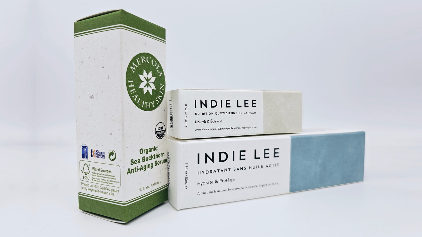 mercola healthy skin and indie lee product packages on white backdrop